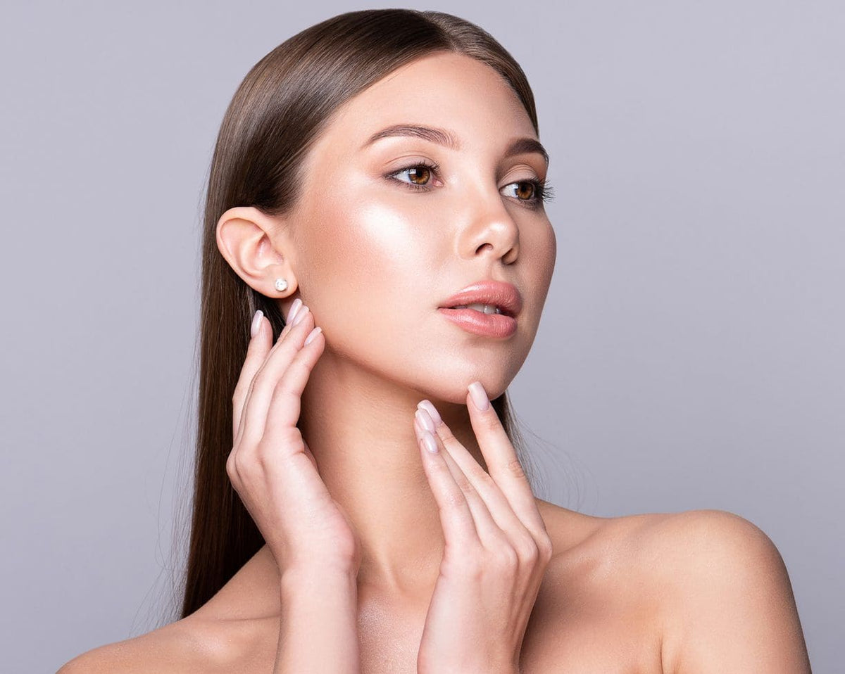 Woman with radiant skin touching her jawline