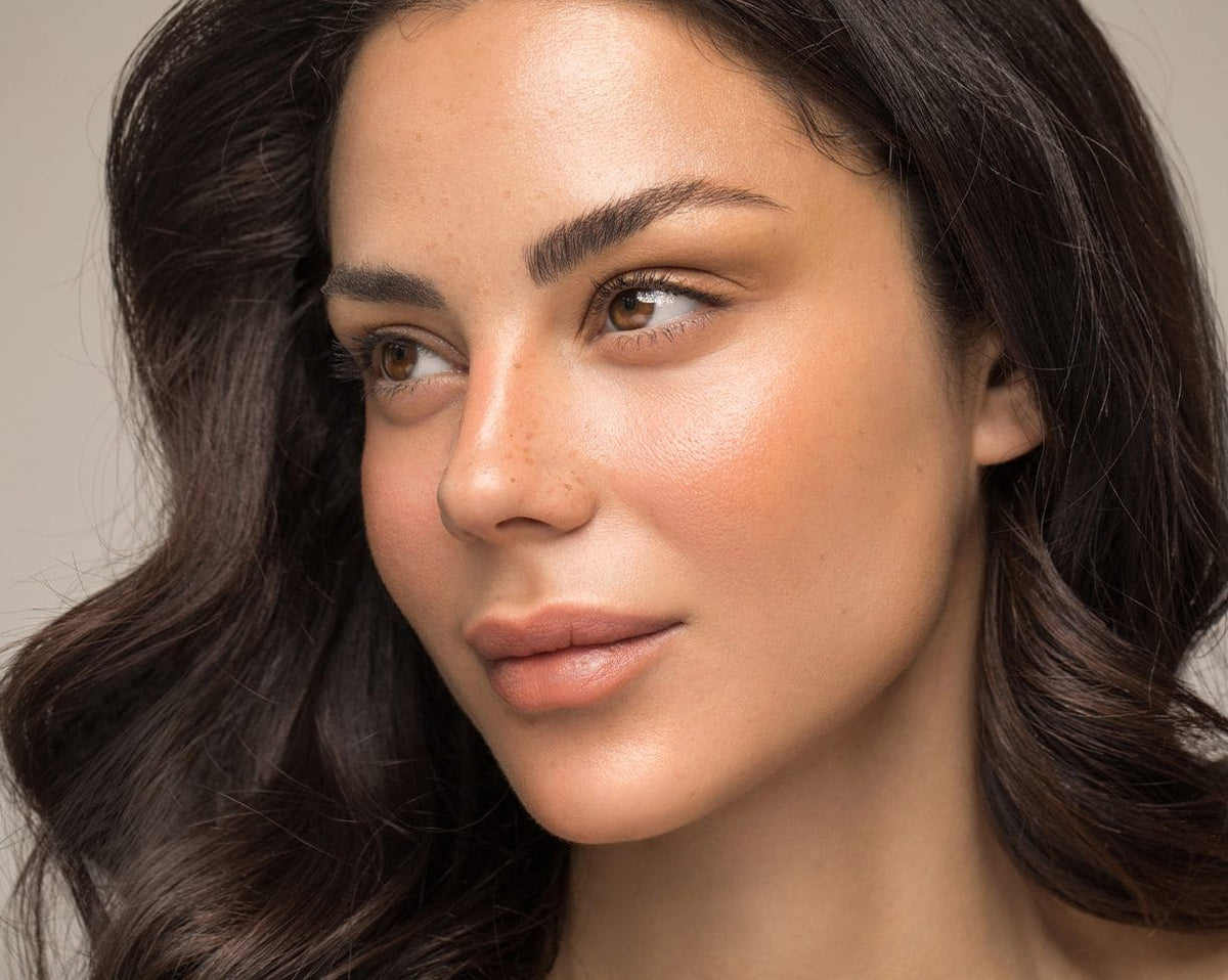 Woman with long dark hair and soft, natural-looking skin