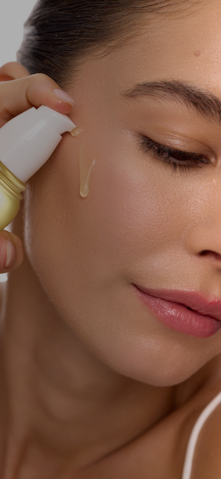 Model applying NassifMD serum to her cheek