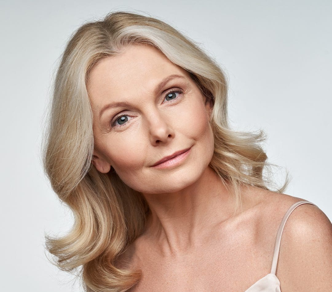 Mature woman with blonde hair and refreshed, healthy-looking skin